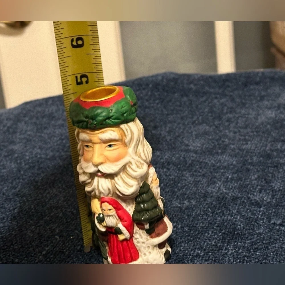 Set of 2 Santa candleholders. Each has smaller different smaller Santas.